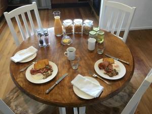 a wooden table with plates of food on it at Pa Road B&B Kerikeri NZ in Kerikeri