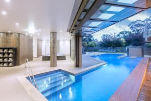 a swimming pool in a house with a glass ceiling at RACV Goldfields Resort in Ballarat