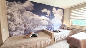 a bedroom with two beds and a snow mural at Apartments KOP Konaci in Kopaonik