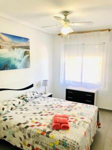 ein Schlafzimmer mit einem Bett mit einer Steppdecke darauf in der Unterkunft Apartamento Santa Pola"The Guitar" 300 m de la playa in Santa Pola