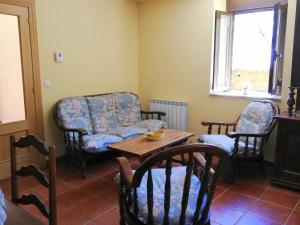 sala de estar con sofá, sillas y mesa en Casa Rural El Secreto del Bosque, en La Omañuela