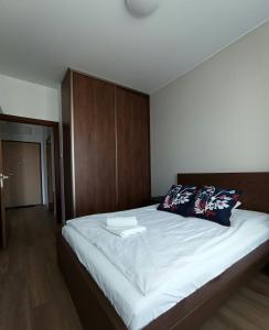 Schlafzimmer mit einem großen Bett mit einem Kopfteil aus Holz in der Unterkunft Cozy Apartment in Wilanów in Warschau
