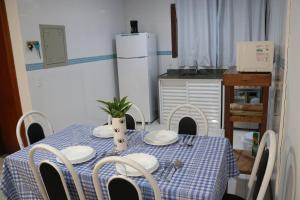 uma cozinha com uma mesa com uma toalha de mesa azul e branca em Búzios Lofts em Búzios