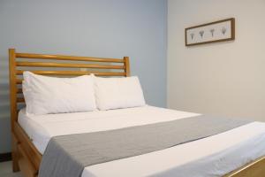 un letto con lenzuola e cuscini bianchi in una stanza di Búzios Lofts a Búzios