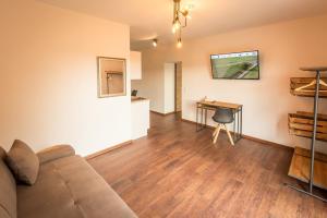 ein Wohnzimmer mit einem Sofa und einem Tisch in der Unterkunft Nürburgring Aparts in Welcherath