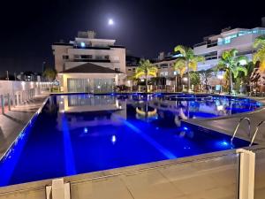 una gran piscina por la noche con iluminación azul en Residencial Mares do Sul, en Florianópolis