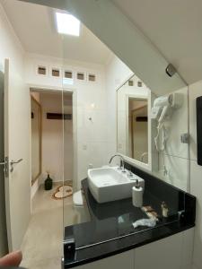 モンテ・ヴェルデにあるCapricho da Natureza Pousadaの洗面台と鏡のあるバスルーム