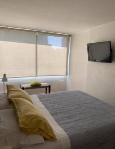 a bedroom with a bed and a flat screen tv at Departamento en el Golf in Santiago