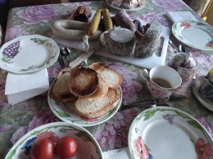 a table with plates of bread and a cup of coffee at Casa Rous in Molló