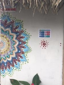 Un muro con un dipinto di un mandala sopra. di Hostal San Andrés de k-noa a Canoa