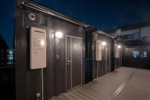 a row of doors on a building at night at HOTEL R9 The Yard Oyama Tenjin in Oyama