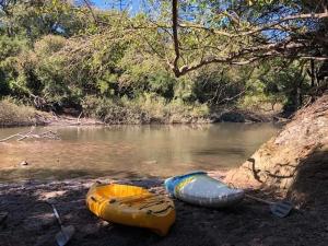 tres canoas sentadas en la orilla de un río en Estancia El Cangue, en Porvenir