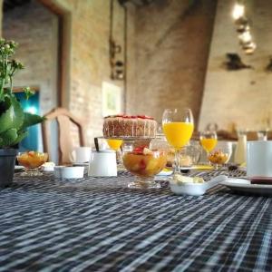 a table with glasses of orange juice and a cake at Estancia El Cangue in Porvenir