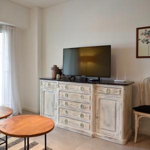 een televisie op een dressoir in een woonkamer bij Costa Esmeralda Departamento para 6 Personas sobre el Golf in Pinamar