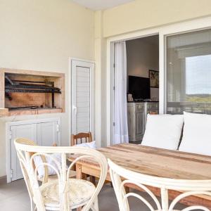 comedor con mesa de madera y sillas en Costa Esmeralda Departamento para 6 Personas sobre el Golf en Pinamar