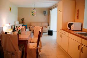 a kitchen with a table and a living room at Gîtes "Les Framboisiers" in Neufchâteau