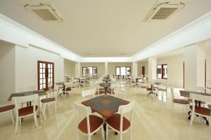 Sawahlunto的住宿－KHAS Ombilin Hotel，用餐室设有桌椅和窗户。