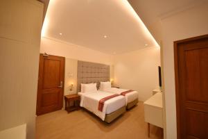 A bed or beds in a room at KHAS Ombilin Hotel