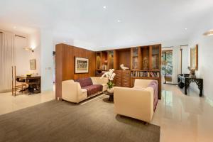 a living room with a couch and chairs and a table at Villa Wantilan Putih in Sanur