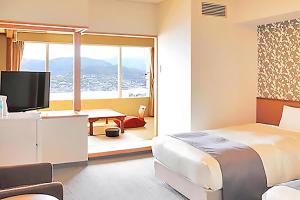 a bedroom with a bed and a desk with a television at Ooedo Onsen Monogatari Nagasaki Hotel Seifu in Nagasaki