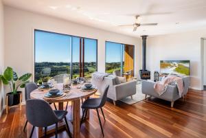 a living room with a table and chairs and a fireplace at The Ridge at Maleny in Maleny