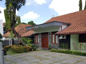 ジョグジャカルタにあるEmbe Pitoe Syariah Gejayan Mitra RedDoorzの赤いドアとパティオのある家