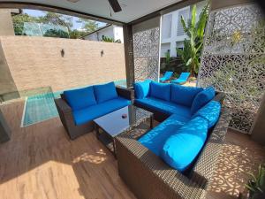 un patio al aire libre con sofás azules y una piscina en The Pearl Luxury Pool Villas, en Ko Chang
