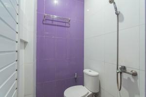 バンドンにあるRedDoorz @ Gatot Subroto Street Bandung 3のトイレと紫色のタイル壁のあるバスルーム