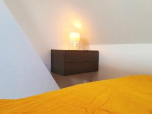a bedroom with a bed and a lamp on a dresser at Yellow Studio in Mons