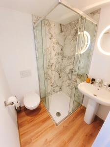 een badkamer met een douche, een toilet en een wastafel bij Yellow Studio in Bergen