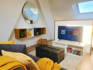 a living room with a couch and a tv and a mirror at Yellow Studio in Mons