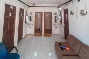 a room with a couch and two sinks and a bathroom at KoolKost Syariah @ Citraland Puri Serang in Serang