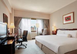 a hotel room with a bed and a desk and a television at The Howard Plaza Hotel Taipei in Taipei +14 photos