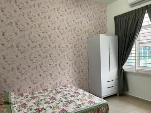 a bedroom with a bed and a dresser in it at Homestay ayer keroh mitc in Malacca