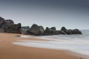 - un groupe de rochers sur une plage avec l'océan dans l'établissement Red Earth - Gokarna, à Ankola