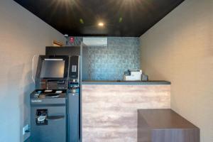 a small kitchen with a stove and a refrigerator at HOTEL R9 The Yard Oyama Tenjin in Oyama