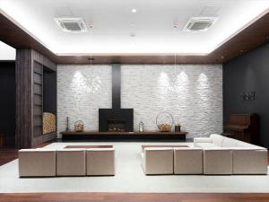 倶知安町にあるトリフィート ホテル＆ポッド ニセコのリビングルーム(白いソファ2台、暖炉付)