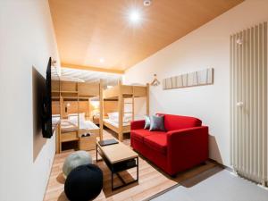 sala de estar con sofá rojo y literas en TORIFITO HOTEL&POD NISEKO, en Kutchan