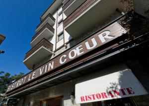 a building with a sign for the vin centric institution at Hotel Au Soleil in Saint Vincent