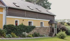 a yellow house with a brown roof and a wooden door at U Devíti vidlí in Žlutice