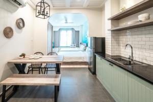 a kitchen with a table and a room with a bed at Mecozy Apartel in Ho Chi Minh City
