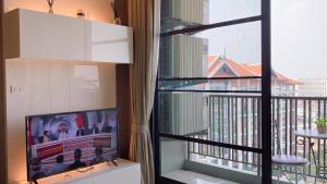 a living room with a tv and a window at luxury high floor loft pool condo with 2 bedrooms in Chiang Mai