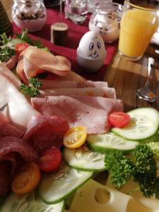 Pension Brandner في Altrandsberg: طبق من الطعام مع اللحوم والخضروات على الطاولة