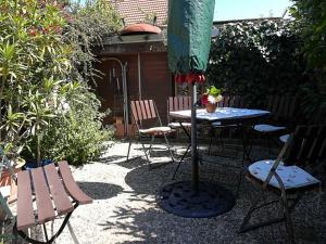a patio with a table and chairs and an umbrella at Ferienwohnung und Bungalow Haegema in Eldena