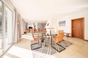 a living room with a glass table and chairs at "Reetland" - Haus Hartwig in Tating