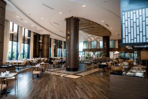 下龙湾Ramada Hotel & Suites by Wyndham Halong Bay View的建筑物内有桌椅的餐厅