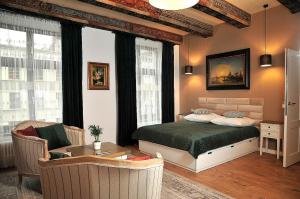 ein Schlafzimmer mit einem Bett, einer Couch und einem Tisch in der Unterkunft Apartamenty Żeglarska 25 in Toruń