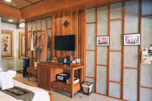 um quarto com uma cama e uma televisão na parede em Buri Gallery House em Chiang Mai