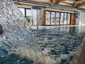 a pool with a fountain in a building at apartamentc312 Bel Mare in Międzyzdroje