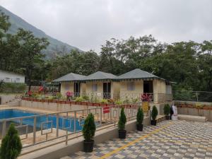 a resort with a swimming pool and a building at Indradhanush Hill Resort in Mulshi